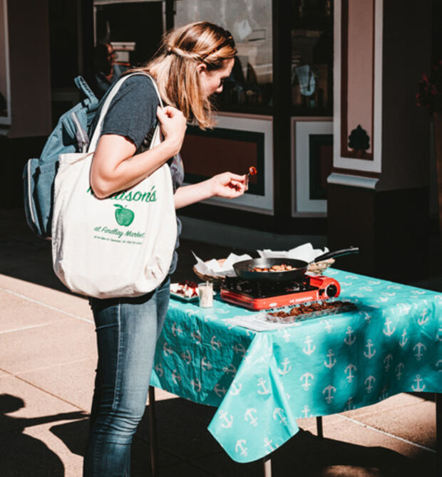 A shopper browsing a vendor table at an outdoor market
