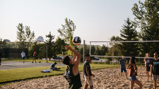 A pickup sand volleyball game at a neighborhood park