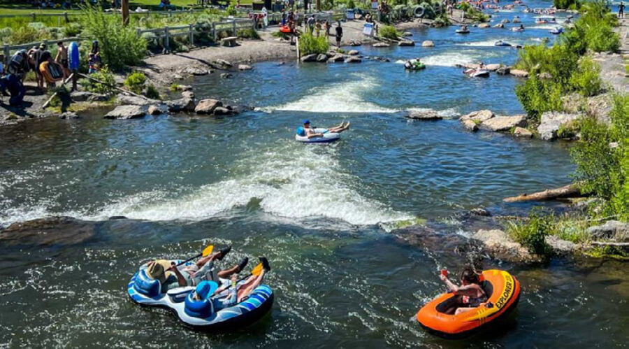 People floating a river in inflatable rafts on a summer day