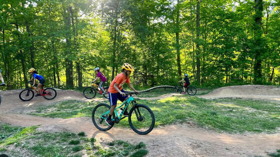 Mountain bikers riding a flow trail through the woods